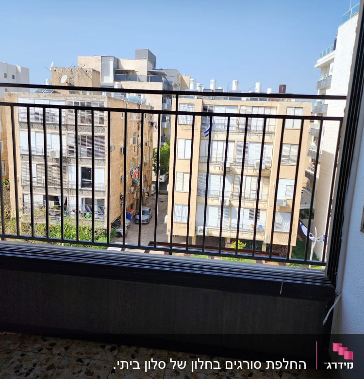 מעקה ברזל במרפסת עם נוף לבניינים